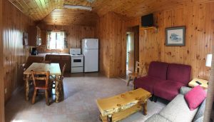 Fully equipped kitchen in a traditional cottage rental with pine accents.