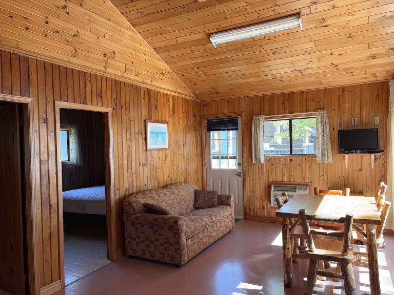 View looking into wood-panelled cottage, showing couch and table