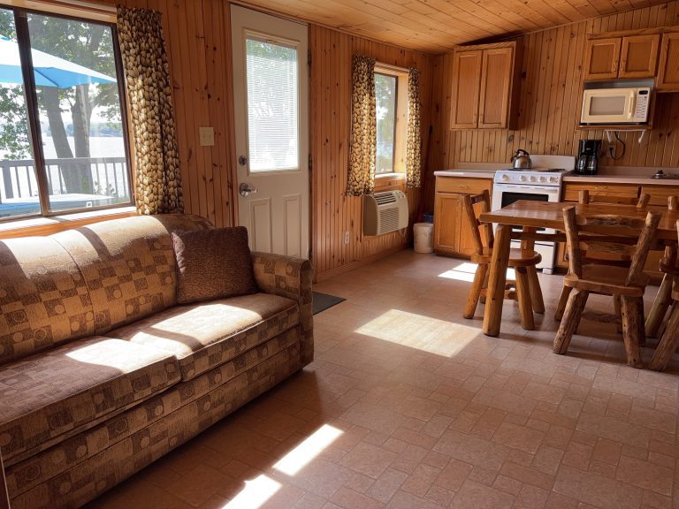 Interior of wood-panelled cottage, with sun shining on couch and edge of kitchen visible