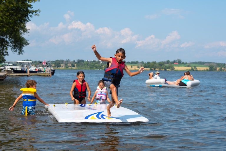 A kid leaps off a floating platform as two others watch