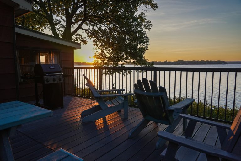 The last rays of sun fall on a patio furniture beside a cottage
